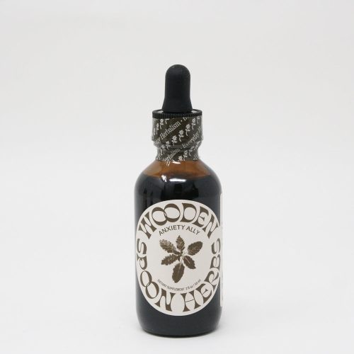 Amber glass dropper bottle labeled "Anxiety Ally Tincture" for herbal use, containing USDA Organic extract to calm nerves, against a white background. Brand name: Wooden Spoon Herbs.